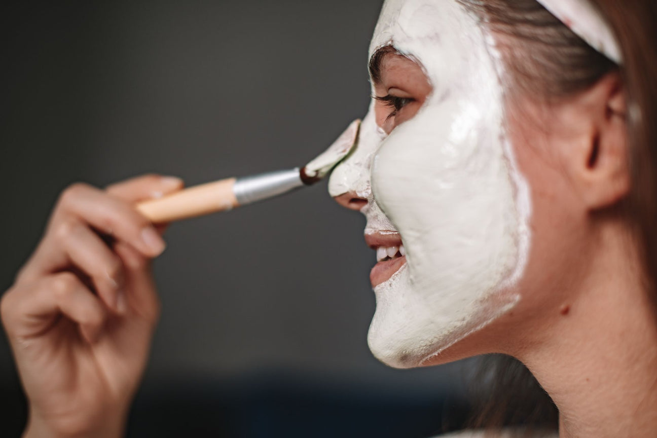 woman using a face mask brush