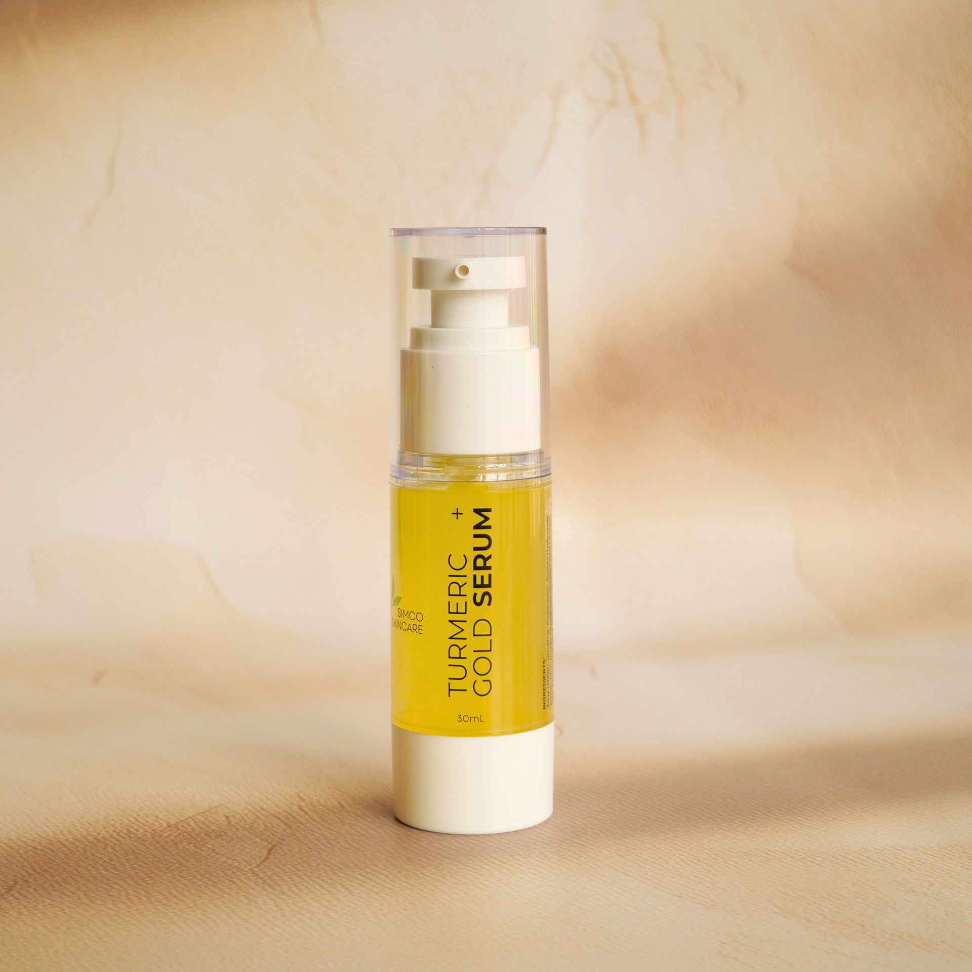 Turmeric Gold Serum bottle on a beige background